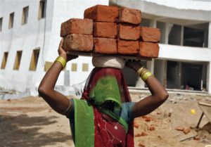 A labourer carries bricks at a residential complex under construction on the outskirts of the western Indian city of Ahmedabad September 2, 2010. Indonesia's efforts to modernise its infrastructure have lagged India's slow-but-steady improvements, though Jakarta's progress could be fast tracked in the eyes of foreign investors with passage of a politically complicated land grab bill. Picture taken September 2, 2010. To match Analysis INFRASTRUCTURE/INDONESIA-INDIA REUTERS/Amit Dave (INDIA - Tags: BUSINESS EMPLOYMENT)